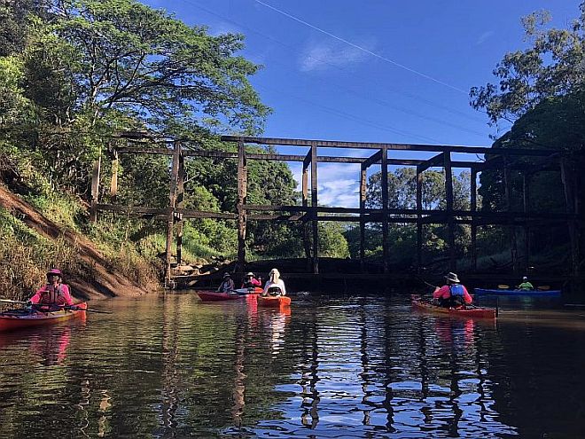 Kayakers under a wooden structure on Lake Wilson